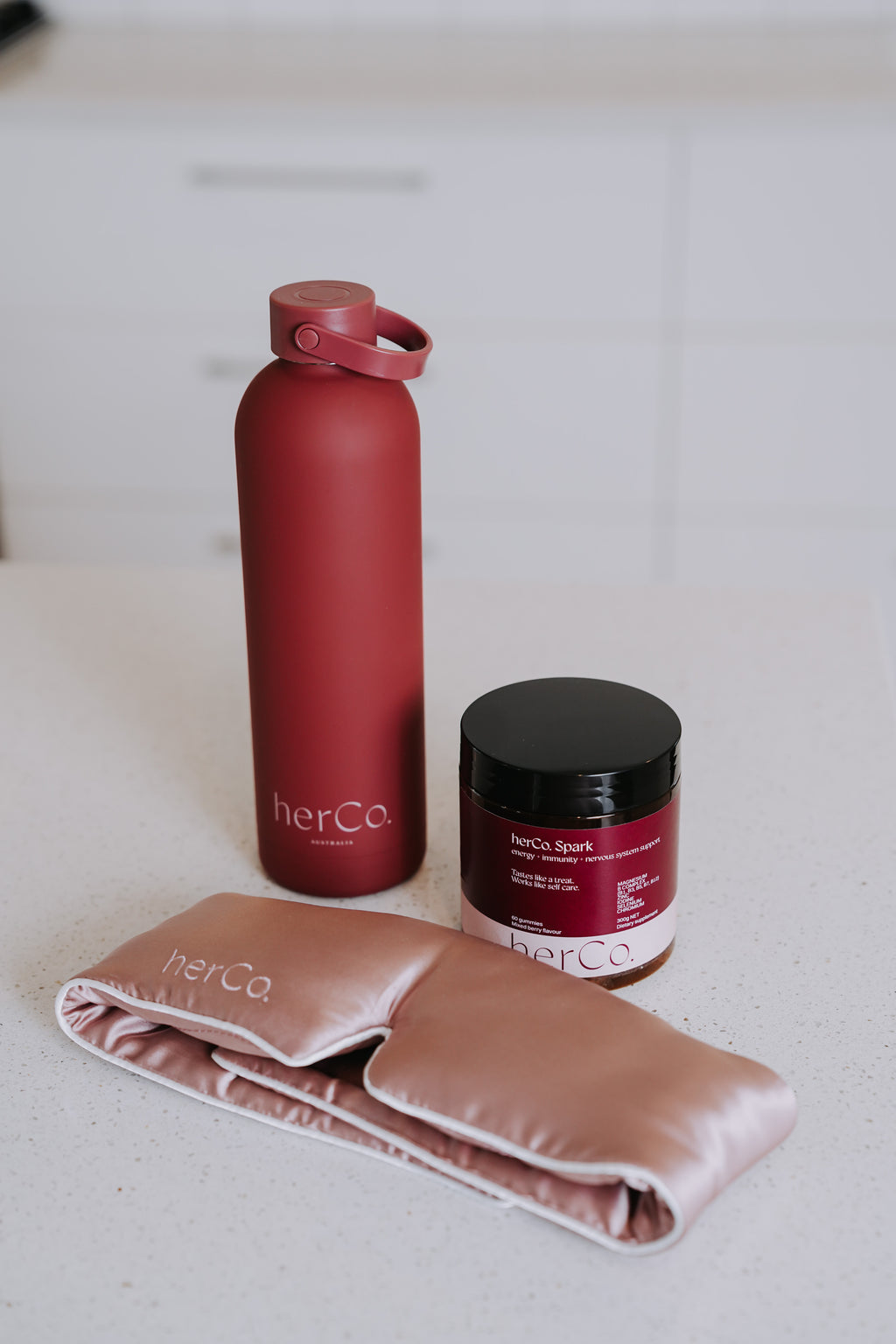 herCo. water bottle, 100% silk eye mask, herCo. Spark gummies (energy + immunity + nervous system support)
