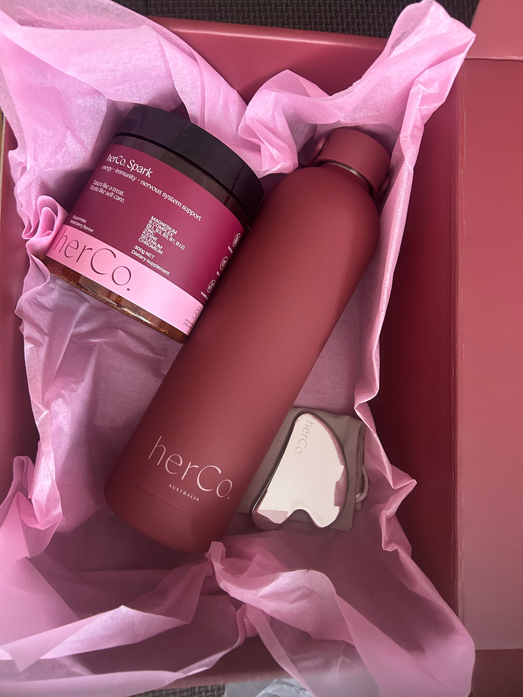 herCo spark gummies, with a dark matte herco waterbootle and luxe gua sha 